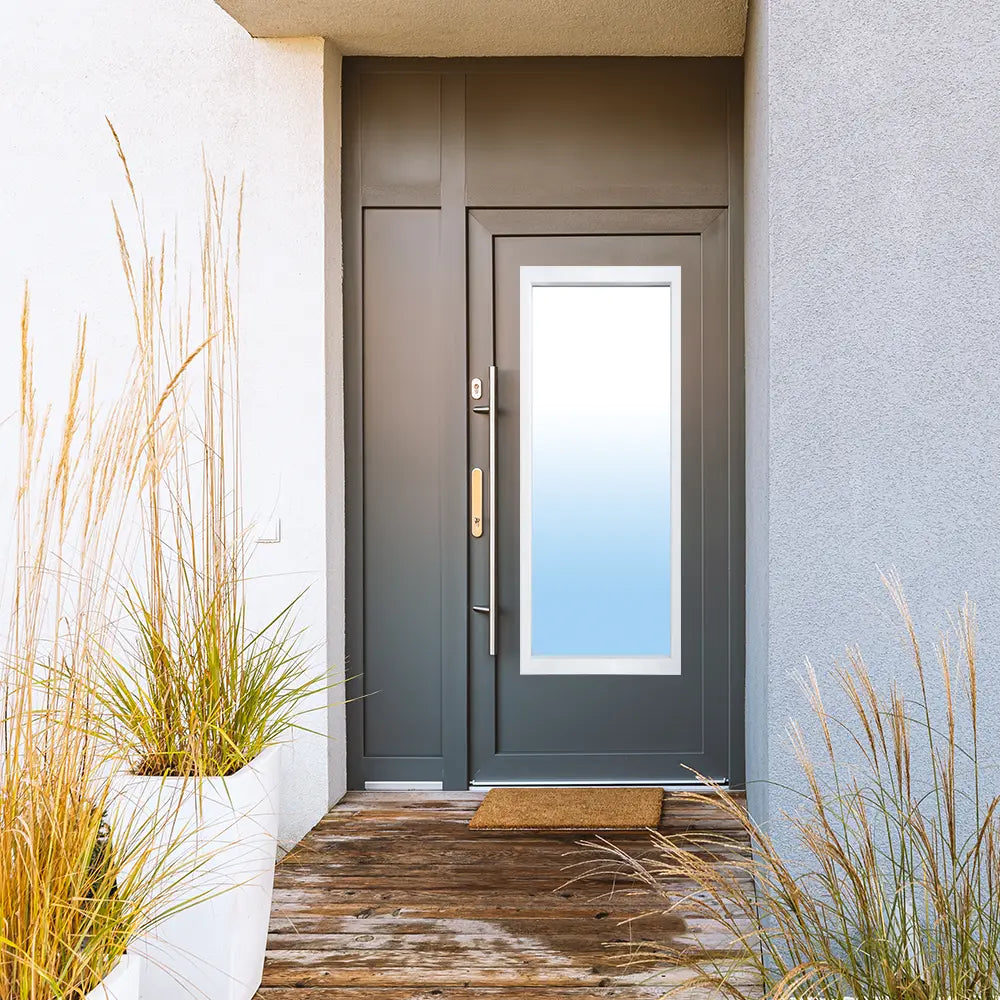 A dark grey modern front door with a 22x64 glass lite installed, brightening the entryway of a contemporary home.